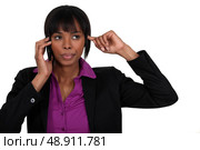 Woman putting finger in ear during call. Стоковое фото, агентство Ingram Publishing / Фотобанк Лори