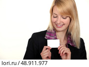 blonde businesswoman with downcast eyes showing business card. Стоковое фото, агентство Ingram Publishing / Фотобанк Лори