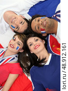 Four young adults supporting the French soccer team. Стоковое фото, агентство Ingram Publishing / Фотобанк Лори