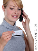 Woman on the phone with her credit card company. Стоковое фото, агентство Ingram Publishing / Фотобанк Лори