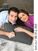 a couple lying on a carpet. Стоковое фото, агентство Ingram Publishing / Фотобанк Лори