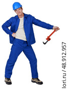 Goofy tradesman holding a pipe wrench. Стоковое фото, агентство Ingram Publishing / Фотобанк Лори
