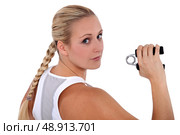 fit woman holding a gripper. Стоковое фото, агентство Ingram Publishing / Фотобанк Лори