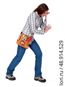 Female builder stood with advertising panel. Стоковое фото, агентство Ingram Publishing / Фотобанк Лори