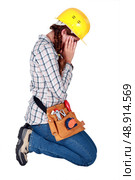 Young woman laborer holding her head. Стоковое фото, агентство Ingram Publishing / Фотобанк Лори
