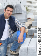 Worker posing with stacks of concrete blocks. Стоковое фото, агентство Ingram Publishing / Фотобанк Лори