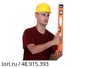craftsman holding a level. Стоковое фото, агентство Ingram Publishing / Фотобанк Лори