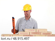 Bricklayer with a spirit level. Стоковое фото, агентство Ingram Publishing / Фотобанк Лори