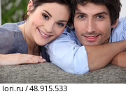Couple embracing on couch. Стоковое фото, агентство Ingram Publishing / Фотобанк Лори