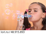 Young girl blowing bubbles. Стоковое фото, агентство Ingram Publishing / Фотобанк Лори