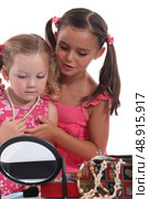 Two young girls playing with jewellery. Стоковое фото, агентство Ingram Publishing / Фотобанк Лори