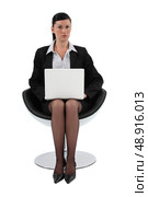 Businesswoman sitting in a modern chair and using her laptop. Стоковое фото, агентство Ingram Publishing / Фотобанк Лори