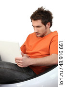 Frowning man using his laptop. Стоковое фото, агентство Ingram Publishing / Фотобанк Лори
