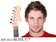 Determined man holding a guitar. Стоковое фото, агентство Ingram Publishing / Фотобанк Лори