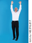 Grey haired businessman reaching into the air. Стоковое фото, агентство Ingram Publishing / Фотобанк Лори