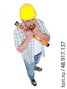 Nervous man holding spirit-level. Стоковое фото, агентство Ingram Publishing / Фотобанк Лори