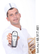 Baker holding forth a telephone. Стоковое фото, агентство Ingram Publishing / Фотобанк Лори