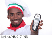 black pizzaiolo holding out phone. Стоковое фото, агентство Ingram Publishing / Фотобанк Лори