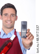 Waitor showing mobile phone. Стоковое фото, агентство Ingram Publishing / Фотобанк Лори