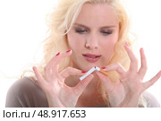 Woman breaking a cigarette. Стоковое фото, агентство Ingram Publishing / Фотобанк Лори