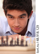 young chessplayer looking focused. Стоковое фото, агентство Ingram Publishing / Фотобанк Лори