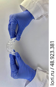 Dentist wearing blue gloves holds transparent dental aligners, showcasing orthodontic care. Стоковое фото, фотограф Анастасия / Фотобанк Лори