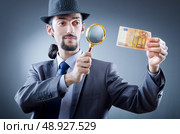 Detective looking at fake money. Стоковое фото, агентство Ingram Publishing / Фотобанк Лори