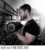 Dumbbell man at gym workout biceps fitness weightlifting. Стоковое фото, агентство Ingram Publishing / Фотобанк Лори