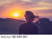 Young woman in field admiring the sunset. Стоковое фото, агентство Ingram Publishing / Фотобанк Лори