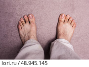 Bare feet of a man standing on a carpet. Стоковое фото, агентство Ingram Publishing / Фотобанк Лори