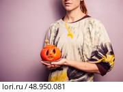 Young woman holding a pumpkin jack’o lantern. Стоковое фото, агентство Ingram Publishing / Фотобанк Лори