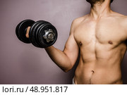 Young man working out with a dumbbell. Стоковое фото, агентство Ingram Publishing / Фотобанк Лори