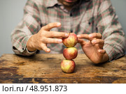 Man with apples balancing on a desk. Стоковое фото, агентство Ingram Publishing / Фотобанк Лори