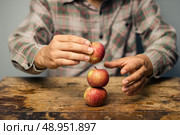 Man with apples on a desk. Стоковое фото, агентство Ingram Publishing / Фотобанк Лори