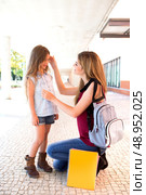 Mother saying goodbye to her daughter at shool. Стоковое фото, агентство Ingram Publishing / Фотобанк Лори