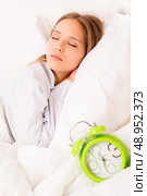 Beautiful woman sleeping with alarmclock on the bed . Стоковое фото, агентство Ingram Publishing / Фотобанк Лори