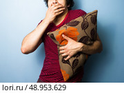 Scared young man clutching a cushion. Стоковое фото, агентство Ingram Publishing / Фотобанк Лори