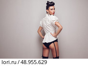 Pin up styling model posing in stocking, high shorts and white shirt. Updo. Стоковое фото, агентство Ingram Publishing / Фотобанк Лори