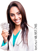 Beautiful brunette doctor showing sealed blisters over white. Стоковое фото, агентство Ingram Publishing / Фотобанк Лори