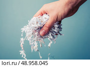 Hand is holding a bunch of shredded paper. Стоковое фото, агентство Ingram Publishing / Фотобанк Лори