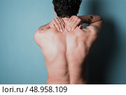Young man is in pain and is massasing his sore neck. Стоковое фото, агентство Ingram Publishing / Фотобанк Лори
