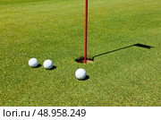 Golfer on the putting green, preparing to put. Стоковое фото, агентство Ingram Publishing / Фотобанк Лори