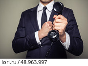 Businessman is handing over a telephone receiver. Стоковое фото, агентство Ingram Publishing / Фотобанк Лори