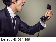 An angry young businesman is on the phone and screaming. Стоковое фото, агентство Ingram Publishing / Фотобанк Лори