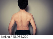 Rear view shot of athletic young man flexing his muscles. Стоковое фото, агентство Ingram Publishing / Фотобанк Лори