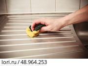 The hand of a young woman is cleaning around the kitchen sink. Стоковое фото, агентство Ingram Publishing / Фотобанк Лори