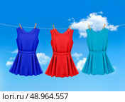 Set of colored dresses hanging on a clothesline on a sunny day. Vector illustration . Стоковая иллюстрация, агентство Ingram Publishing / Фотобанк Лори