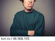 A young man is gesturing and pulling silly faces. Стоковое фото, агентство Ingram Publishing / Фотобанк Лори