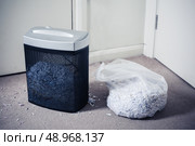 A paper shredder and a bag of shredded documents by the door. Стоковое фото, агентство Ingram Publishing / Фотобанк Лори