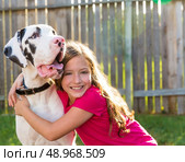 great dane and kid girl hug playing together at backyard outdoor. Стоковое фото, агентство Ingram Publishing / Фотобанк Лори
